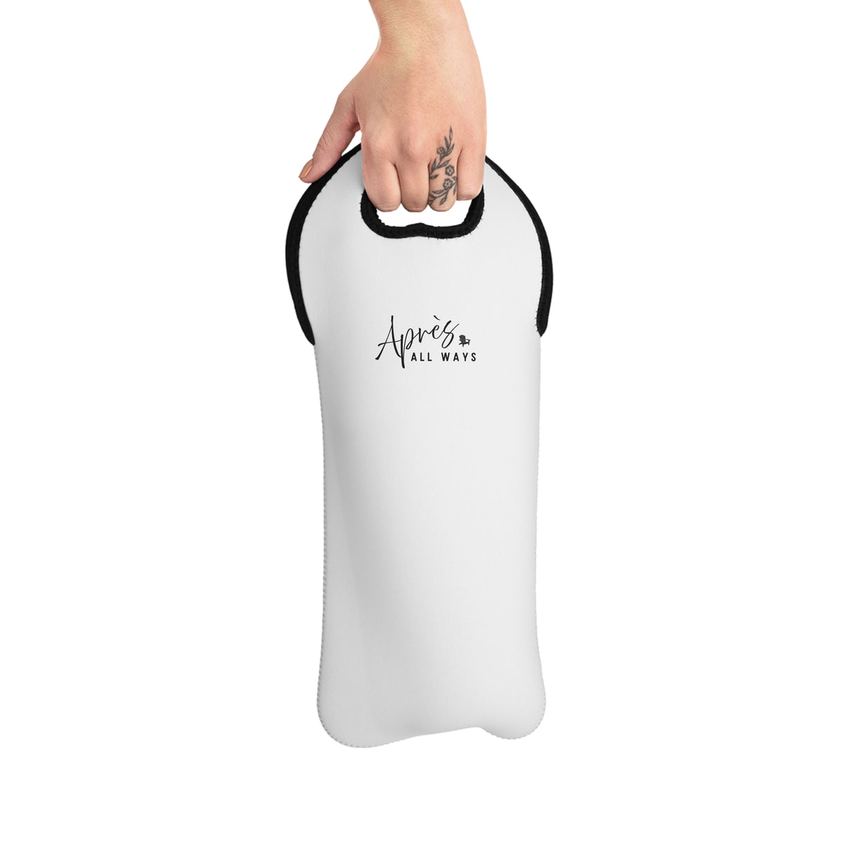 Hand carrying a white single-bottle wine tote by its cutout handle, with black trim and a black Après All Ways logo, against a white background.